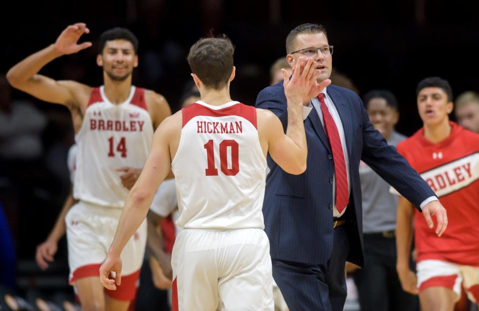 Bradley head coach Brian Wardle high-fives Connor Hickman after a three-pointer late in the first half of the Braves' season opener Monday, Nov. 7, 2022 at Carver Arena. The Braves defeated the Rangers 93-59.