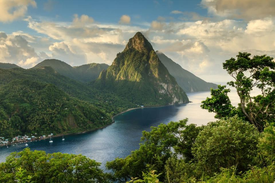 <p>St. Lucia looks like a scene set in Jurassic Park. The serene tapering mountains are the Pitons, located on the western side of the island. Other wonders you’ll find are volcanic beaches, fishing villages and diving spots.</p><p>Where to stay: <a href="https://www.jademountain.com/" rel="nofollow noopener" target="_blank" data-ylk="slk:Jade Mountain" class="link ">Jade Mountain</a> is a majestic escape that might just seem like a dream. This hotel was built into the side of a cliff along the ocean. Without a fourth wall in the rooms, guests can stargaze from their bed at nighttime, and breathe the ocean air. It’s designed around its surroundings from bringing in local farming to indigenous herbal medicine and cacao harvesting.</p>