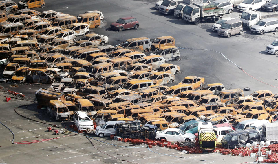 This aerial photo shows burned cars in Nishinomiya, Wednesday, Sept. 5, 2018, a day after a powerful typhoon hit western Japan. About 100 cars at a seaside dealership burned after their electrical systems were shorted out by sea water, fire officials and news reports said. (Hiroko Harima/Kyodo News via AP)