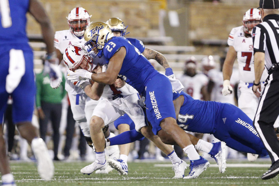 FILE - SMU quarterback Shane Buechele (7) is stopped short of a first down by Tulsa linebacker Zaven Collins (23) during the second half of an NCAA college football game in Tulsa, Okla., in this Saturday, Nov. 14, 2020, file photo. Zaven Collins is a small-town player with big-time talent. He was overlooked after a stellar high school career in Hominy, Okla., a town with about 3,500 people. He’s got the nation’s attention now -- the 6-foot-4, 260-pound linebacker is a finalist for the Butkus and Nagurski Awards. (AP Photo/Joey Johnson, File)