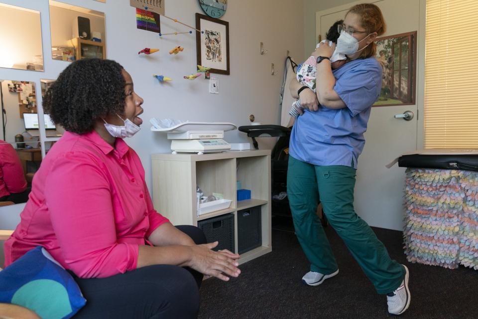 Capri Isidoro, of Ellicott City, Md., left, watches as Ann Faust, an International Board Certified Lactation Consultant (IBCLC), holds her one-month-old daughter Charlotte, Monday, May 23, 2022, as part of a lactation consultation in Columbia, Md., at Baby and Me Lactation Services. Baby Charlotte was delivered via emergency c-section and given formula by hospital staff. Isidoro has been having trouble with breastfeeding and has been searching for a formula that her daughter can tolerate well. "If all things were equal I would feed her with formula and breastmilk," says Isidoro, "but the formula shortage is so scary. I worry I won't be able to feed my child." (AP Photo/Jacquelyn Martin)