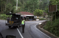 <p>A police officer patrol near abandoned houses in Besakih, located a few kilometers away from the mountain’s slopes, in Bali, Indonesia, Sept. 25, 2017. More than 35,000 people have fled a menacing volcano on the Indonesia tourist island of Bali, fearing will erupt for the first time in more than half a century as increasing tremors rattle the region. (AP Photo/Firdia Lisnawati) </p>