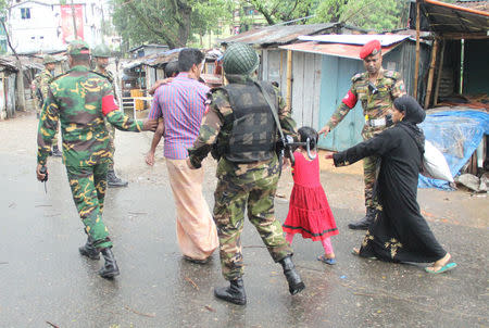 Bangladesh Army personnel escort a family after rescuing them from a militant hideout during an operation in Sylhet, Bangladesh, March 25, 2017. Picture taken March 25, 2017. REUTERS/Stringer