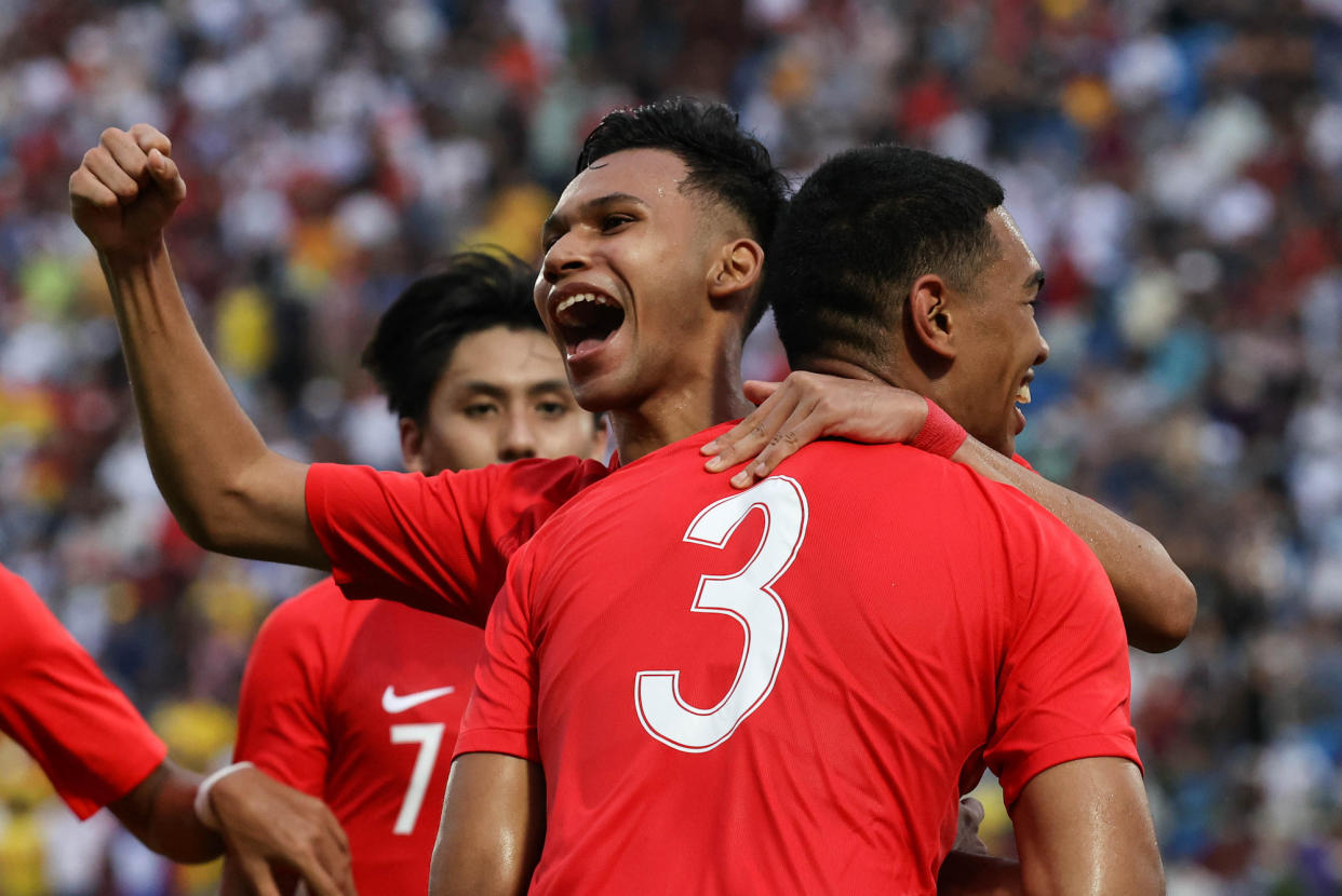 Singapore's Khairin Nadim (centre) hugs scorer Jordan Emaviwe (jersey No.3) after the defender's late equaliser in their 2-2 draw against Laos at the SEA Games. (PHOTO: Sport Singapore/Jeremy Lee)