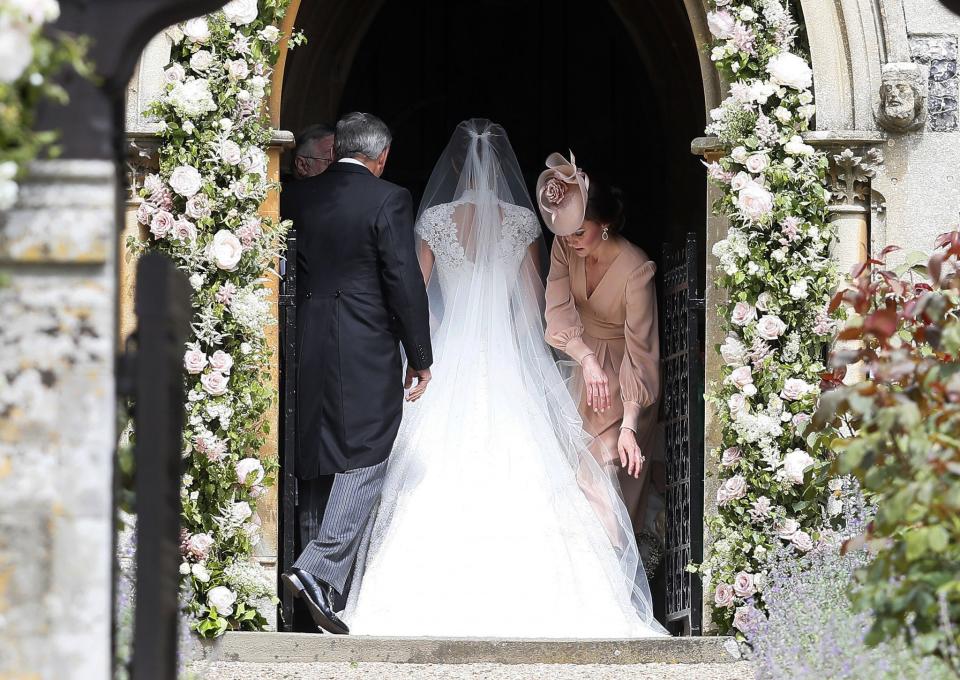 <p>While not officially the matron of honor, Kate acted as any sister would and helped her sister with her train before she walked down the aisle. (Photo: PA) </p>