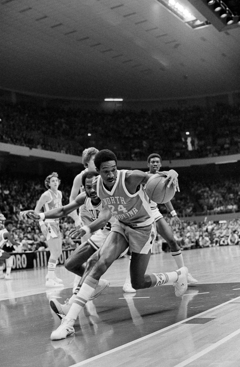 FILE - Forward Walter Davis (24) of North Carolina, grabs the ball in front of Duke's George Moses, left, during an NCAA college basketball Big Four Basketball Tournament in Greensboro, N.C., Jan. 3, 1976. Davis, a five-time NBA All-Star who had his number retired by the Phoenix Suns, has died. He was 69. Davis was star in college for North Carolina where he played for the late Dean Smith. The school's release said Walter Davis died Thursday morning, Nov. 2, 2023, of natural causes while visiting family in Charlotte, North Carolina. (AP Photo/Harold Valentine, File)