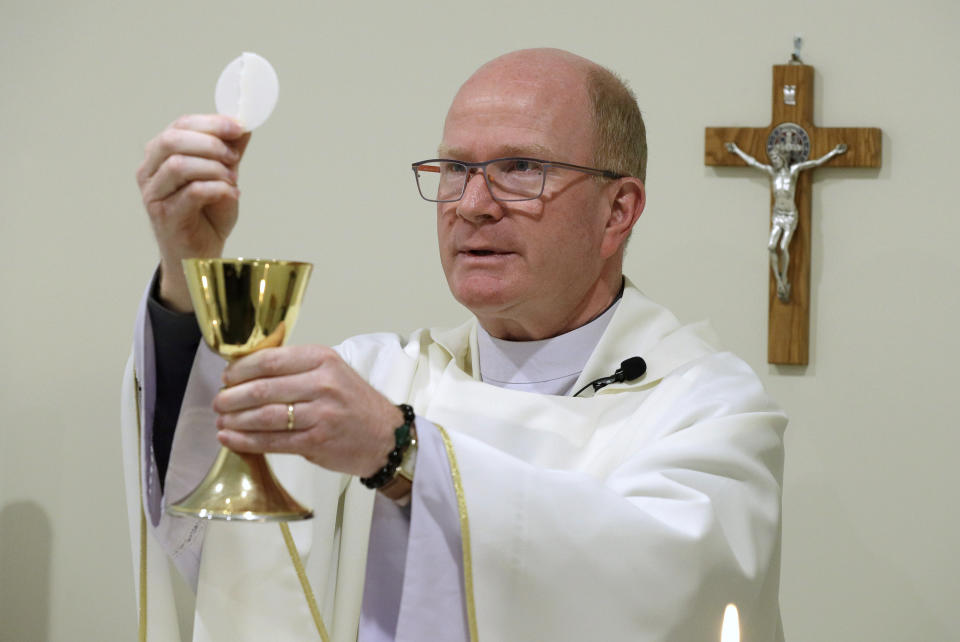 Father Simon Eccleston hosts an online Easter Mass in a room at the Christchurch Catholic Diocese offices in Christchurch, New Zealand, Monday, April 13, 2020. New Zealand is into week three of an unprecedented 28 day lockdown in a bid to stop the spread of the coronavirus. (AP Photo/Mark Baker)