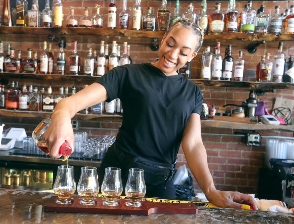 Perfect Pour bartender Aleiah Carmona pours a whiskey flight at the restaurant in downtown Akron.