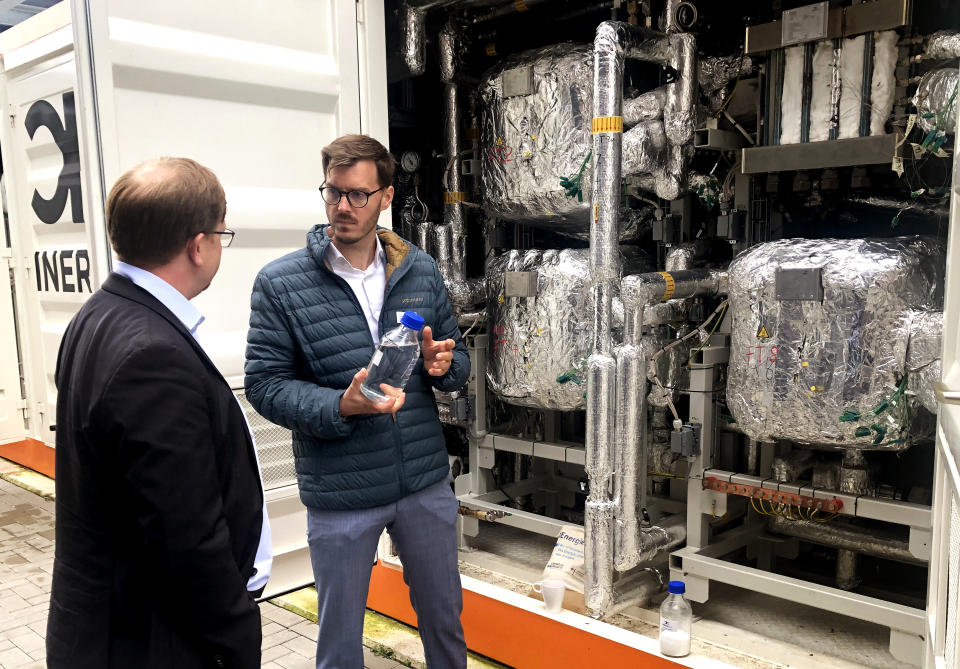 Tim Boeltken, managing director and founder of INERATEC, holds a bottle with e-fuel at the 'Atmosfair' synthetic kerosene plant in Werlte, Germany, Monday, Oct. 4, 2021. German officials are unveiling a facility in Werlte, near Germany's northwestern border with the Netherlands, what they say will be the world's first commercial plant for making synthetic kerosene as part of an effort to reduce the climate impact of flying. (AP Photo/Aleksandar Furtula)