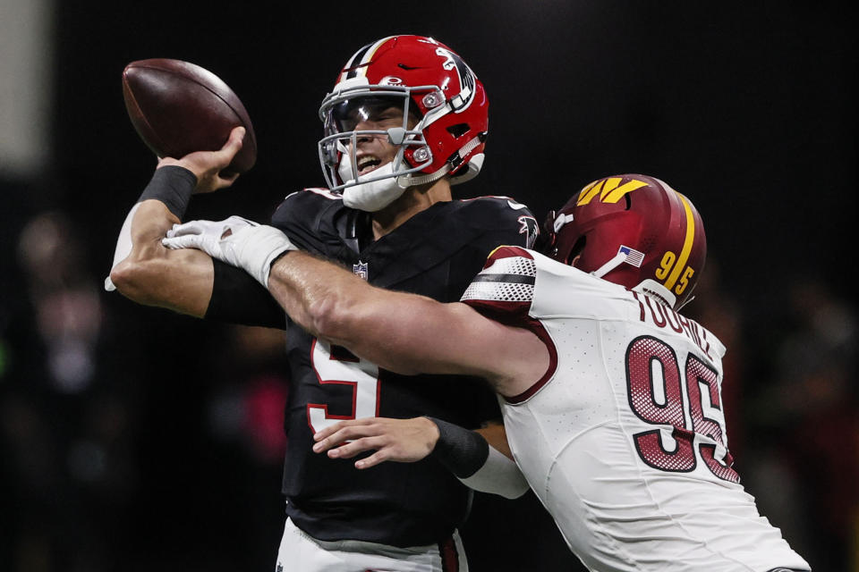 Atlanta Falcons quarterback Desmond Ridder (9) passes the ball under pressure by Washington Commanders defensive end Casey Toohill (95) during the first half of an NFL football game, Sunday, Oct. 15, 2023, in Atlanta. (AP Photo/Butch Dill)