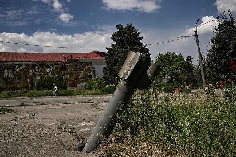 La cola de un cohete se clava en un pavimento en la ciudad de Lysychansk, en la región oriental de Ucrania de Donbass el 17 de junio de 2022, cuando la guerra entra en su día 114. (Photo by ARIS MESSINIS / AFP)