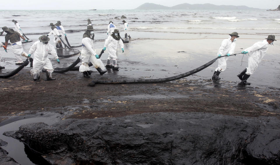 Workers remove crude oil during a clean up operation on the beach of Prao Bay on Samet Island in Rayong province eastern Thailand Tuesday, July 30, 2013. About 50,000 liters (13,200 gallons) of crude oil that leaked from a pipeline operated by PTT Global Chemical Plc, has reached the popular tourist island in Thailand's eastern sea despite continuous attempts to clean it up. (AP Photo)