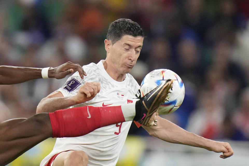 France's Aurelien Tchouameni, left, fights for the ball with Poland's Robert Lewandowski during the World Cup round of 16 soccer match between France and Poland, at the Al Thumama Stadium in Doha, Qatar, Sunday, Dec. 4, 2022. (AP Photo/Moises Castillo)