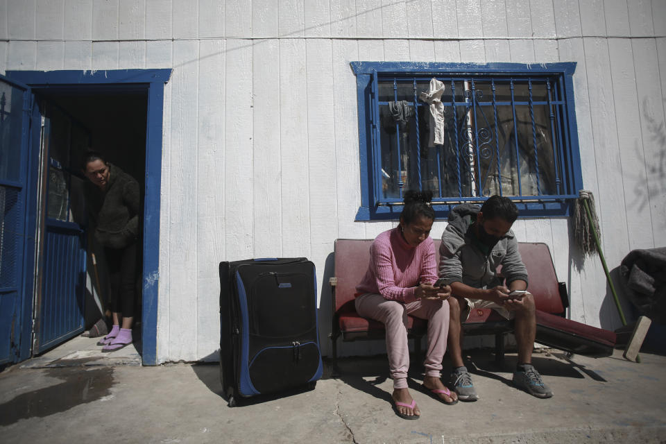 Miguel Carvallo and his wife, both from Honduras, use their phones to request an appointment for asylum in the U.S., at the Pan de Vida shelter in Ciudad Juarez, Mexico, Friday, Feb. 19, 2021. After waiting months and sometimes years in Mexico, people seeking asylum in the United States are being allowed into the country starting Friday as they wait for courts to decide on their cases, unwinding one of the Trump administration's signature immigration policies that President Joe Biden vowed to end. (AP Photo/Christian Chavez)