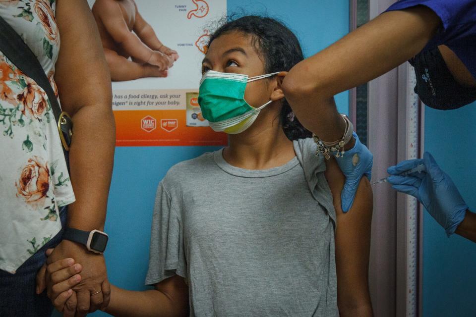 Rebecca Pablo, 12, Palm Springs, holds her mother's hand as medical assistant supervisor Bianca Lantigua at FoundCare PEDS North offices in West Palm Beach in July 2021
.