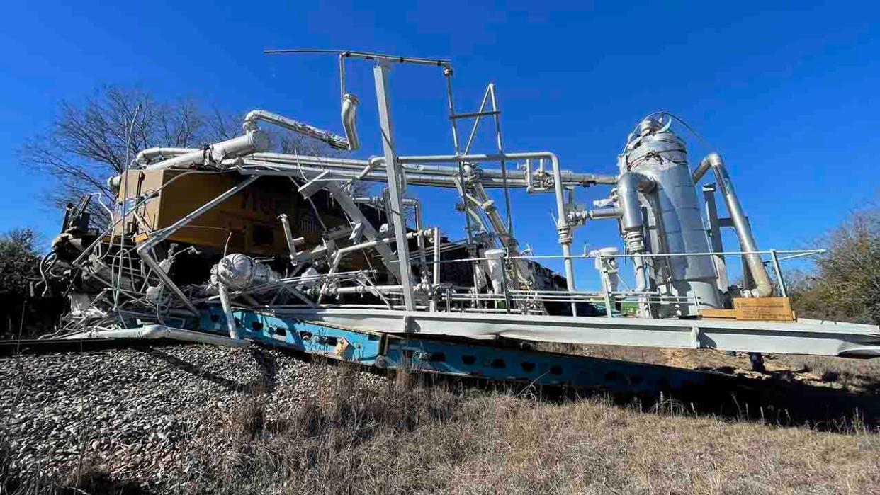 broken semi-truck trailer and derailed train