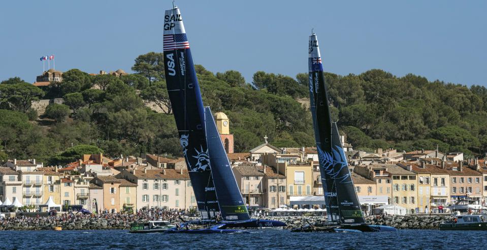 USA SailGP Team helmed by Jimmy Spithill and New Zealand SailGP Team helmed by Peter Burling sail past the Old Town and Bell Tower of Saint Tropez on Race Day 2 of the Range Rover France Sail Grand Prix in Saint Tropez, France, Sunday, Sept. 11, 2022. (Bob Martin/SailGP via AP)