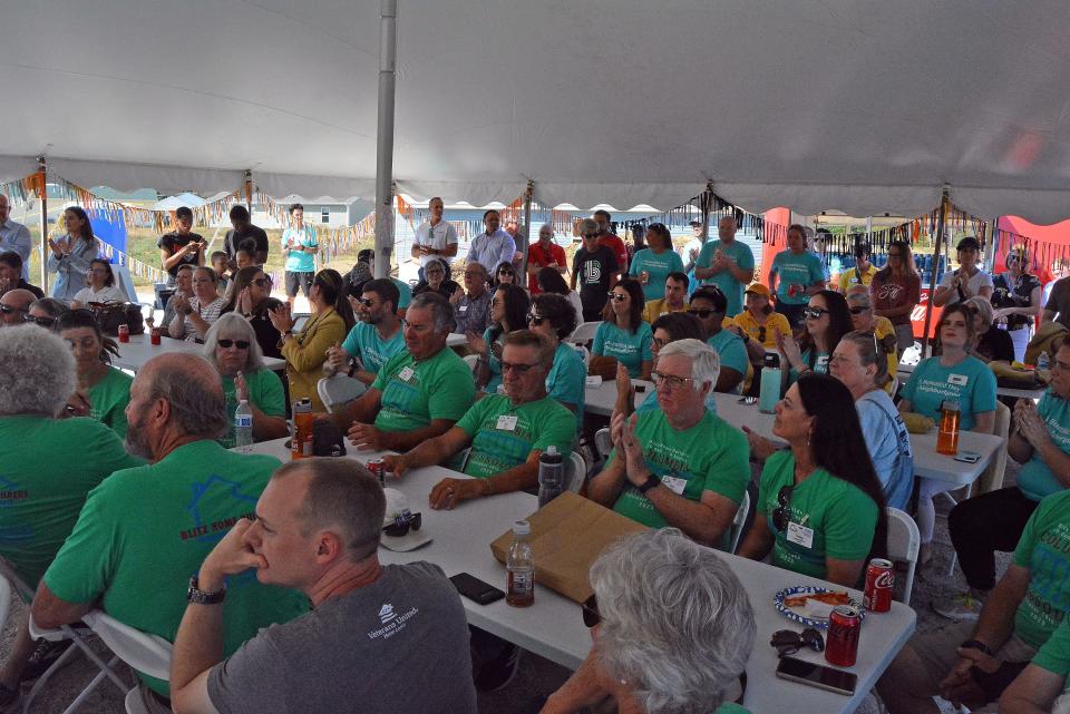 Volunteers, sponsors, families and more listen Friday as Show-Me Central Habitat for Humanity celebrates the successful completion of its Blitz Build.