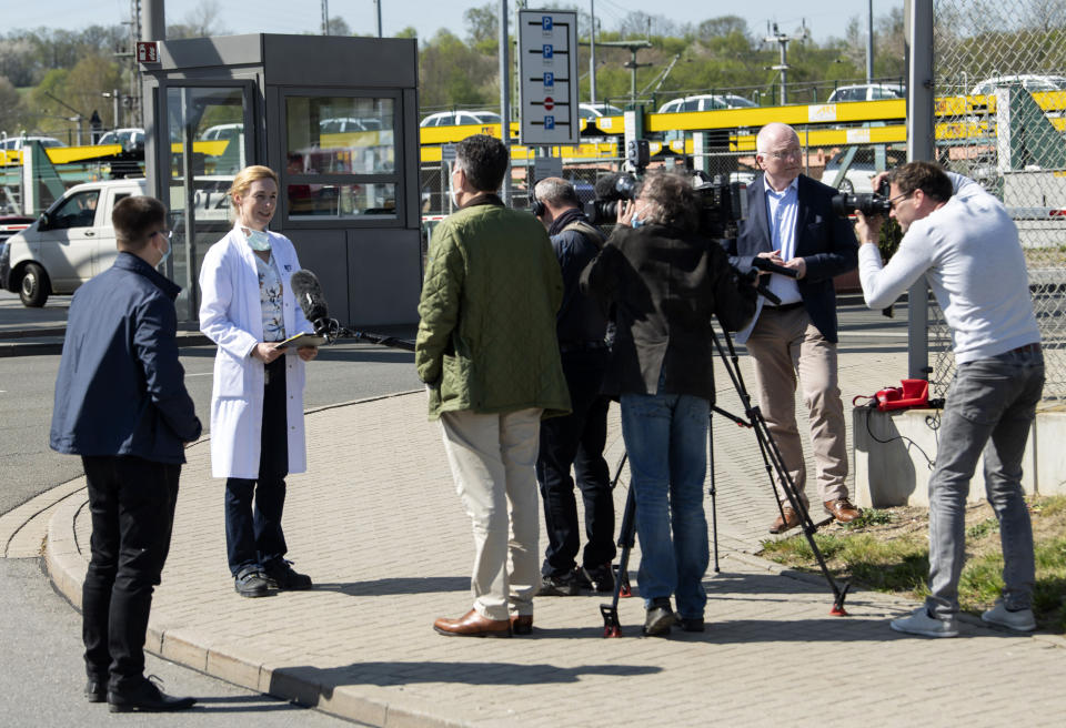 Company doctor Katrin Beck, 2nd of left, talks with journalists during the production restart of the plant of the German manufacturer Volkswagen AG (VW) in Zwickau, Germany, Thursday, April 23, 2020. Volkswagen starts with step-by-step resumption of production. The car company are completely converting the plant in Zwickau from 100 percent combustion engine to 100 percent electric. (AP Photo/Jens Meyer)