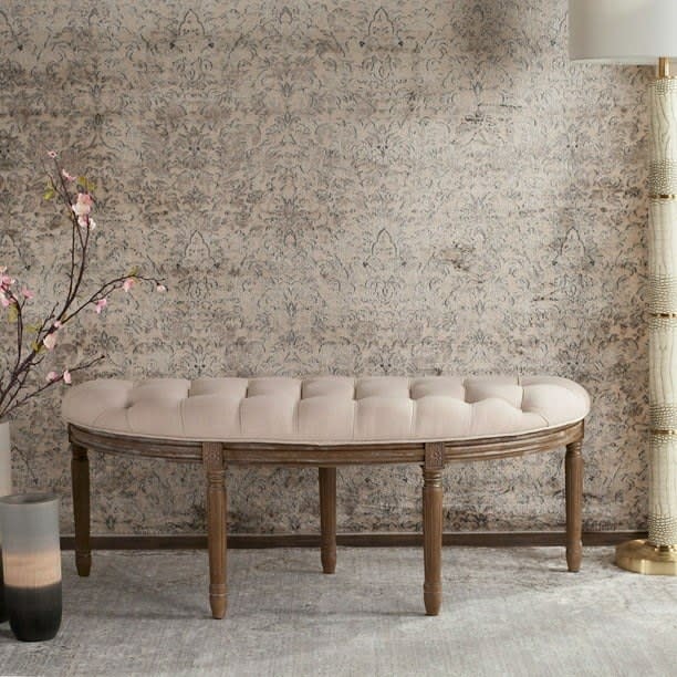 the semi-circle bench with wooden legs and a tufted cushion against a wall