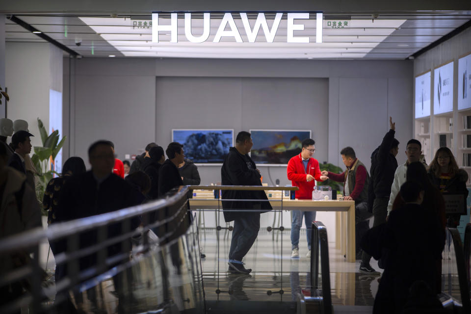 In this Nov. 20, 2019, photo, customers shop at a Huawei store at a shopping mall in Beijing. The founder of Huawei says the Chinese tech giant is moving its U.S. research center to Canada due to American restrictions on its activities. (AP Photo/Mark Schiefelbein)