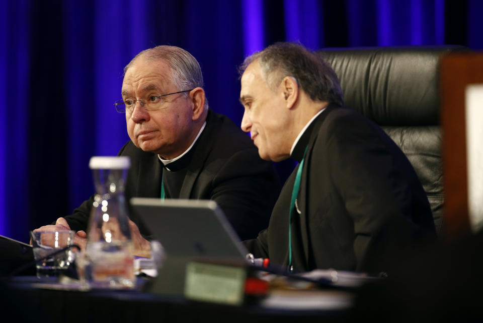 FILE - In this Nov. 12, 2018, file photo, Archbishop Jose Gomez of Los Angeles, vice president of the United States Conference of Catholic Bishops, left, sits with Cardinal Daniel DiNardo of the Archdiocese of Galveston-Houston, USCCB president, before the conference's annual fall meeting in Baltimore. Gomez overwhelmingly won election Tuesday, Nov. 12, 2019, as the first Hispanic to head the U.S. Conference of Catholic Bishops. (AP Photo/Patrick Semansky, File)