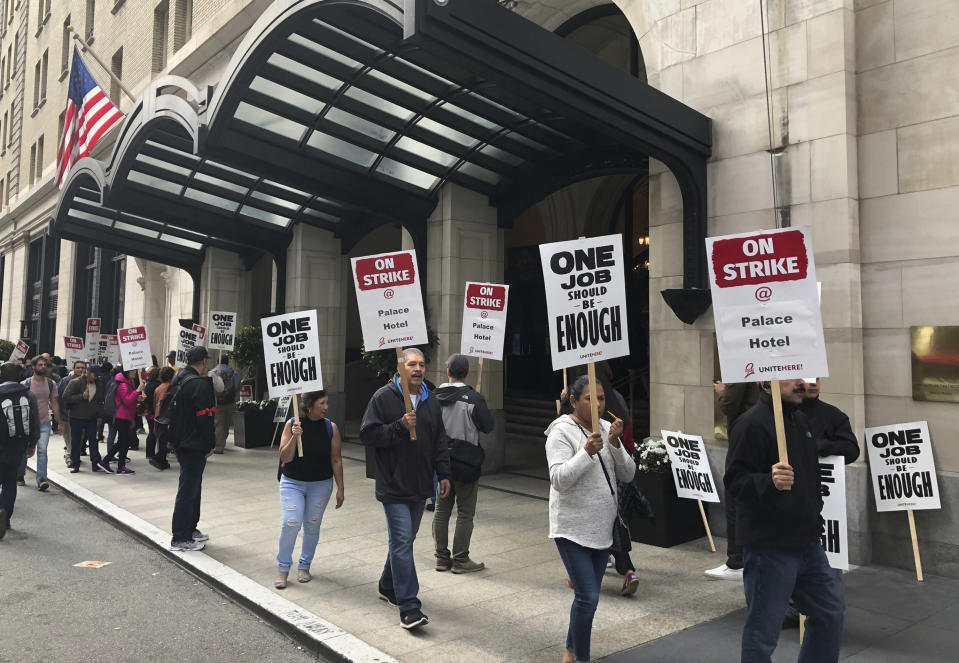 Hotel workers strike outside the Palace Hotel in San Francisco, Calif., Thursday, Oct. 4, 2018. Thousands of housekeepers, cooks and other Marriott hotel workers are on strike in San Francisco and San Jose after months of negotiating for a wage increase. (AP Photo/Juliet Williams)