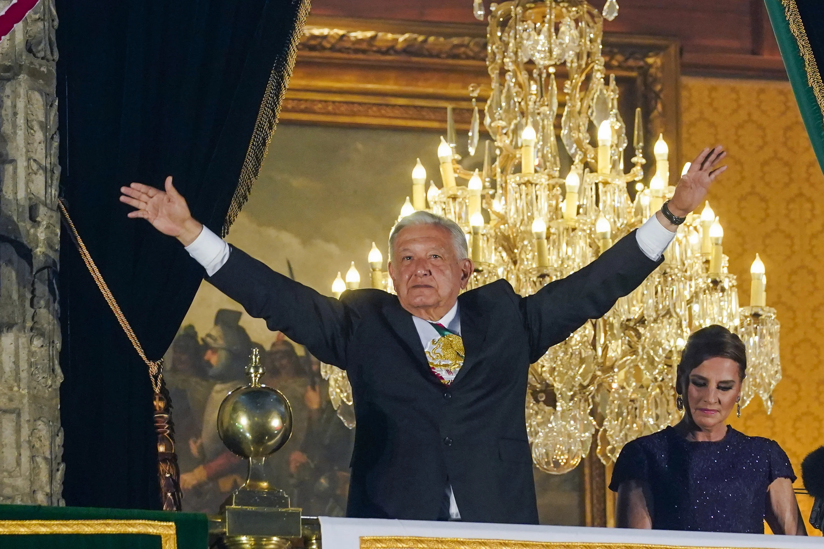 El presidente López Obrador en el balcón del Palacio Nacional acompañado de la primera dama Beatriz Gutiérrez. (AP/Felix Marquez)