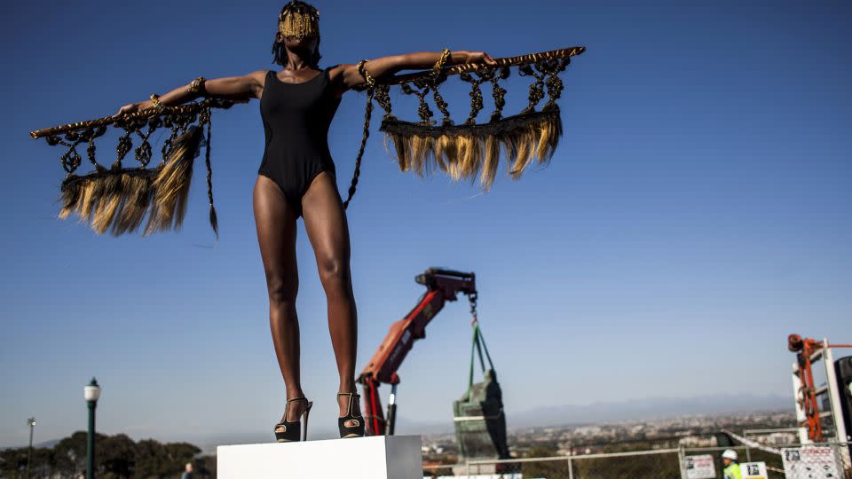 Artist Sethembile Msezane on a plinth in front of the statue of British colonialist Cecil John Rhodes. Its removal was the culmination of a month of protests by students. - Charlie Shoemaker/Getty Images