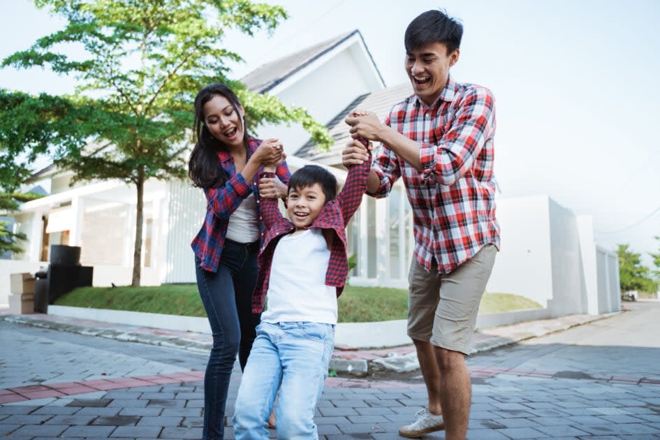 Couple playing with their son outside home