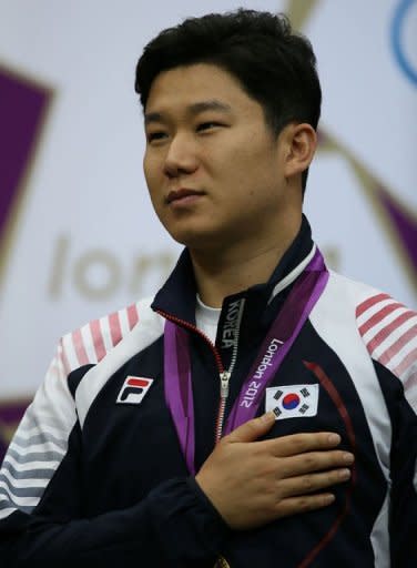 Gold medallist South Korean Jin Jongoh listens to the playing of his national anthem during the podium ceremony for the 10m Air Rifle Men final at the Royal Artillery Barracks in London on July 28, 2012, during The London 2012 Olkympic Games. AFP PHOTO/MARWAN NAAMANI