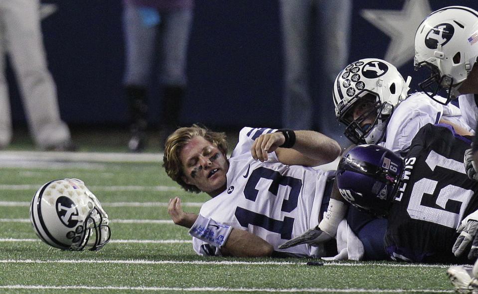 BYU quarterback Riley Nelson looses his helmet on the sack by TCU defensive tackle Jon Lewis during game, in Arlington, Texas, on Friday, Oct. 28, 2011. | LM Otero, Associated Press