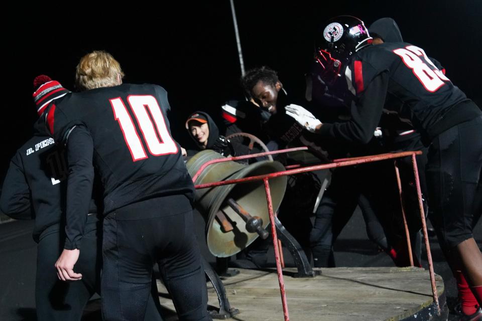 Members of the Marion Harding football team ring the victory bell Friday night at Harding Stadium after a 30-26 win over Pleasant.