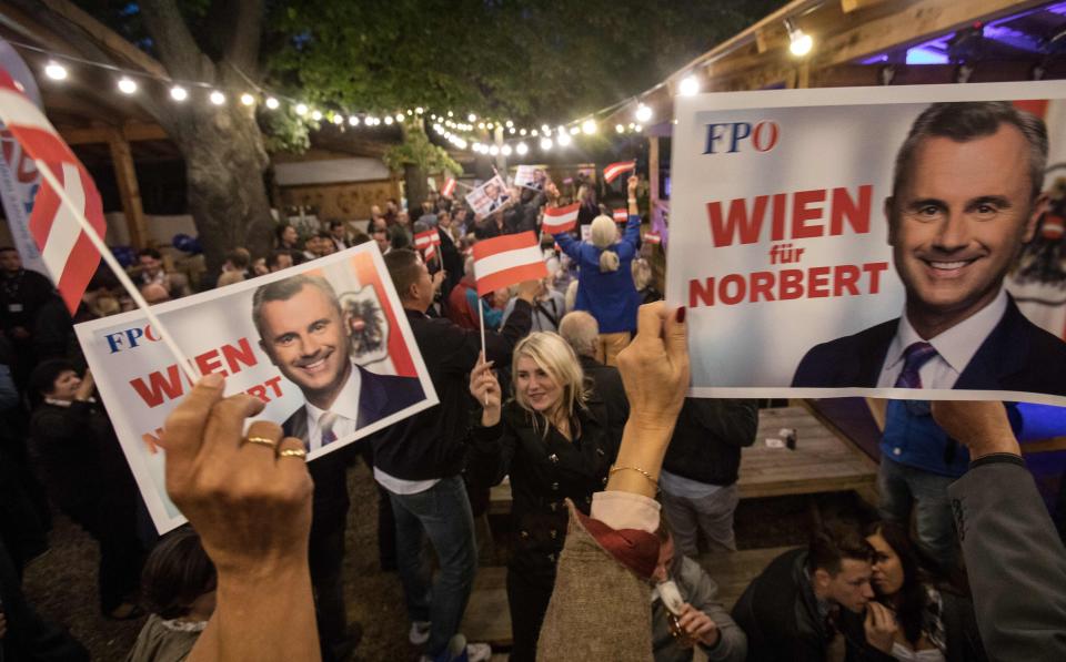 Supporters of the far-right Freedom Party hold campaign posters featuring their party leader Norbert Hofer during a September political event. The new government coalition has pushed back on the Freedom Party. (Photo: ALEX HALADA via Getty Images)