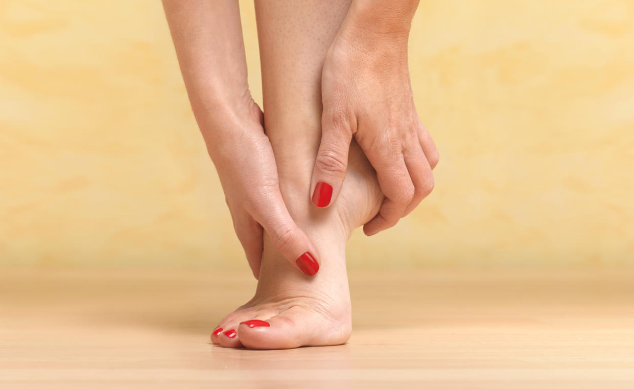 woman removed shoes to massage painful foot