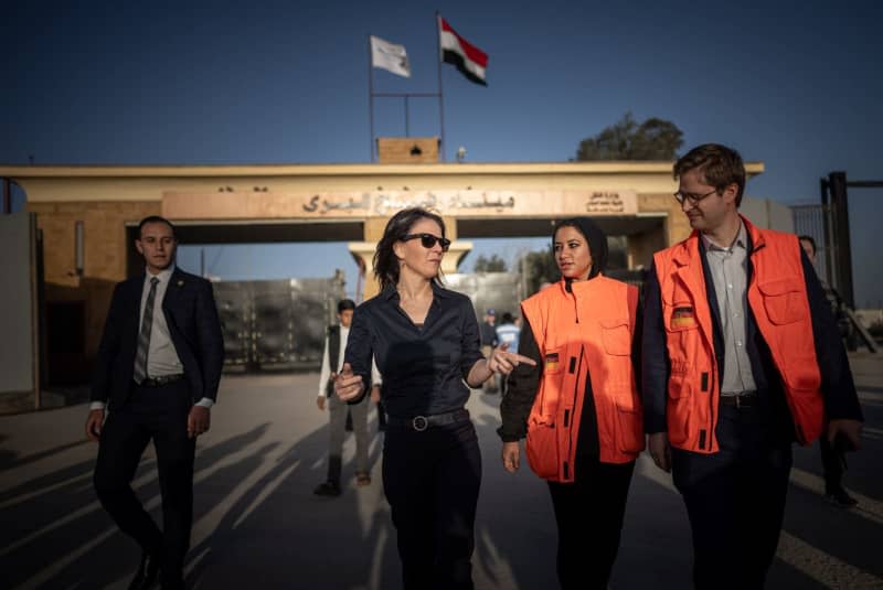 German Foreign Minister Annalena Baerbock (C) talks to staff at the German Embassy during a visit to the border crossing to the Gaza Strip in Rafah. Michael Kappeler/dpa