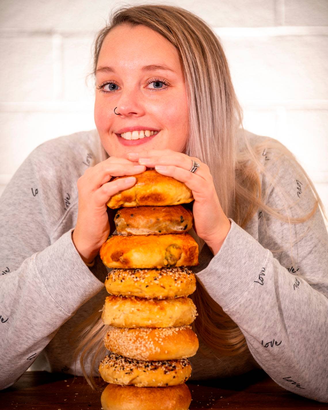 Brittany Erwin, 31, owner of B’s Bagels and Butters in Gig Harbor, poses for a portrait with an amalgam of tasty bagels on Thursday, Nov. 11.