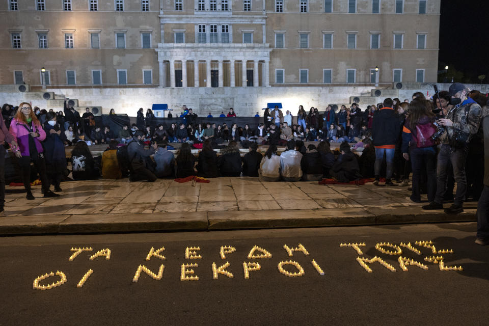 Demonstrators take part in a protest in front of the parliament, in Athens, Saturday, March 4, 2023. Supporters of the Greek Communist party gathered to protest the deaths of dozens of people late Tuesday, in Greece's worst recorded rail accident. The slogan reads : "Their profit, Our dead". (AP Photo/Yorgos Karahalis)