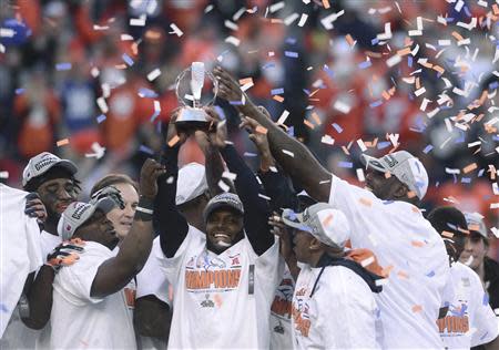 Denver Broncos players hold up the Lamar Hunt Trophy after they defeated the New England Patriots in the NFL's AFC Championship football game in Denver, January 19, 2014. REUTERS/Mark Leffingwell