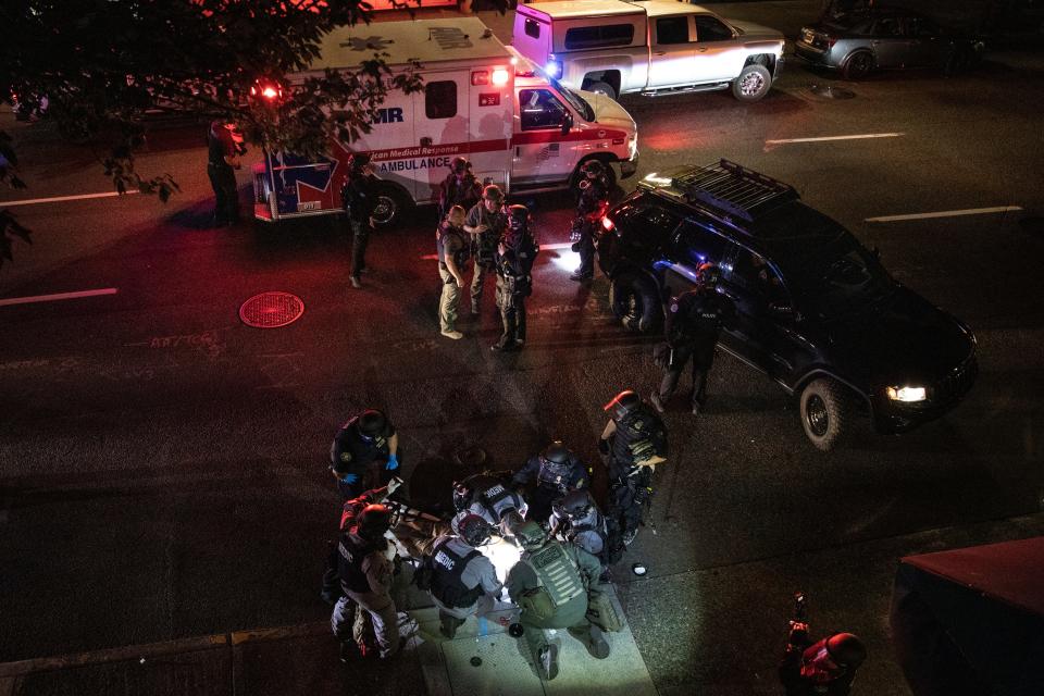 A man is treated by medics after being shot during a confrontation on Saturday, Aug. 29, 2020, in Portland, Oregon. Fights broke out as a large caravan of supporters of President Donald Trump drove through the city, clashing with counter-protesters.