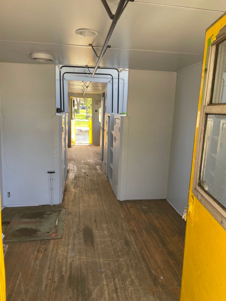 Inside the Chessie System caboose with newly painted white walls and a bright yellow door. 