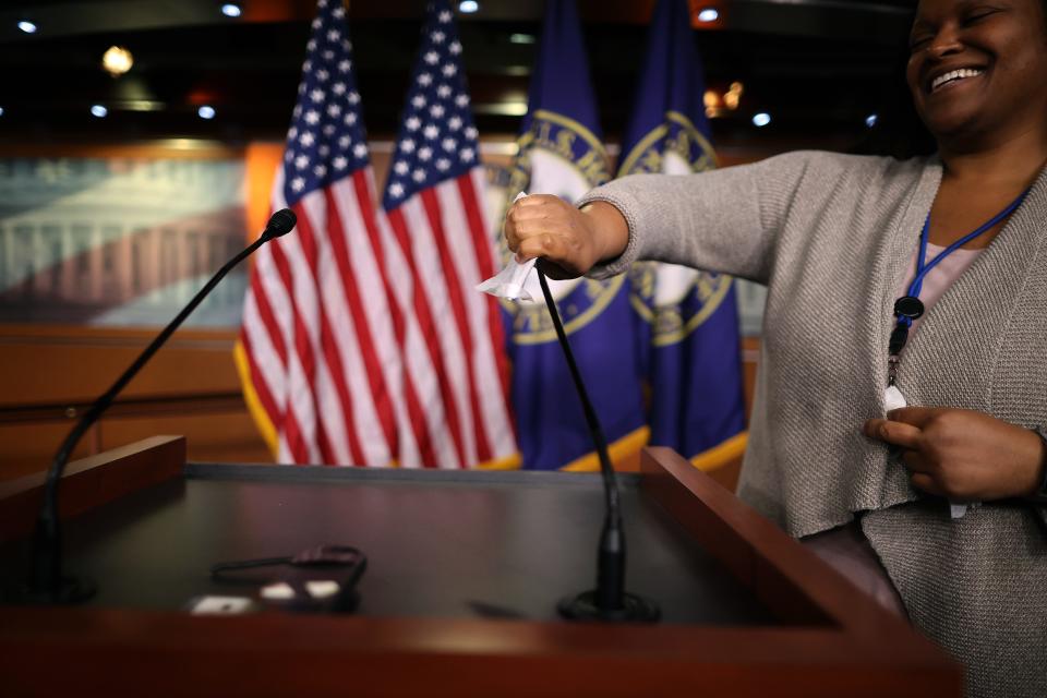 House of Representatives Media Logistics Coordinator Kinsey Harvey disinfects the podium following a news conference with U.S. House Speaker (D-CA) about the ongoing coronavirus outbreak at the U.S. Capitol March 26, 2020 in Washington, DC.