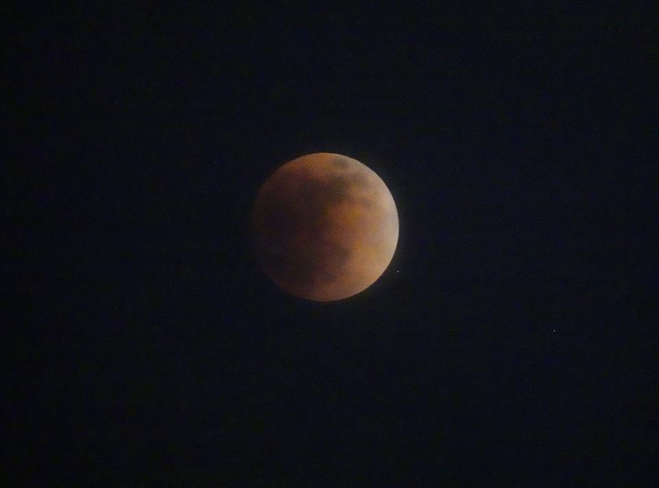 The moon glows red during a lunar eclipse as seen from Mesa on Sunday, May 15, 2022.