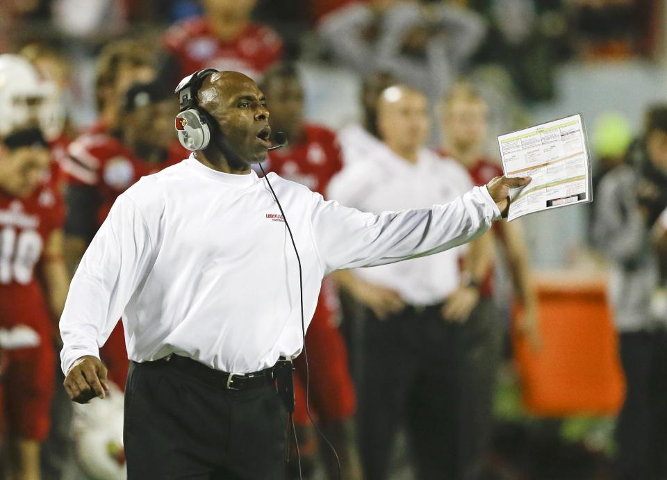 FILE - In this Dec. 28, 2013, file photo, Louisville head coach Charlie Strong calls out to players on the field during the second half of the Russell Athletic Bowl NCAA college football game against Miami in Orlando, Fla. Strong remains Louisville's football coach for the moment, telling assistants Saturday morning, Jan. 4, 2014, he hasn't decided to accept Texas' offer to become its coach. (AP Photo/John Raoux, File)