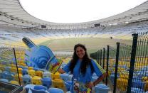 A volunteer poses for a picture inside the Maracana stadium, one of the stadiums hosting the 2014 World Cup soccer matches, during a press visit in Rio de Janeiro. (Sergio Moraes/Reuters)