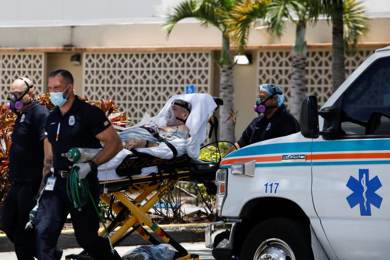 Emergency Medical Technicians (EMT) leave with a patient at Hialeah Hospital where the coronavirus disease (COVID-19) patients are treated