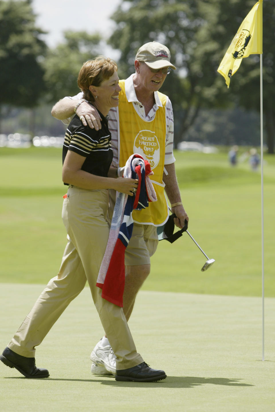 Suzy Whaley is congratulated by her caddie Jim “Buck” McGann after the second round of the Greater Hartford Open on July 25, 2003, at TPC at River Highlands in Cromwell, Connecticut. Whaley did not make the cut. (Photo by Elsa/Getty Images)