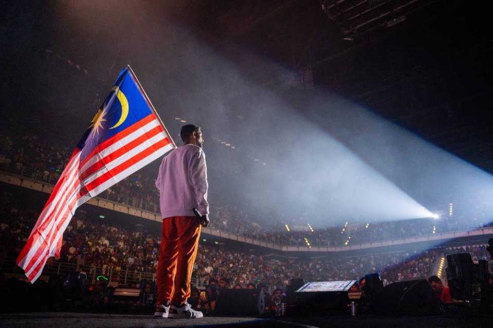 That proud moment: Balan Kashmir holding our Malaysian flag while the crowd sings along to the National Anthem. — Pic by: Mc Entertainment.
