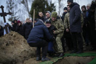 Anya Korostenska drops to her knees before the grave of her fiance Oleksiy Zavadskyi, a Ukrainian serviceman who died in combat on Jan. 15 in Bakhmut, during his funeral in Bucha, Ukraine, Thursday, Jan. 19, 2023. (AP Photo/Daniel Cole)