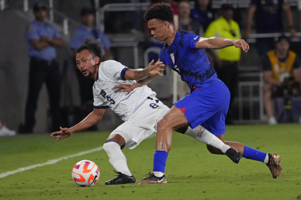 El Salvador midfielder Bryan Landaverde, left, loses his footing as he goes after the ball against United States defender Antonee Robinson, right, during the first half of a CONCACAF Nations League soccer match Monday, March 27, 2023, in Orlando, Fla. (AP Photo/John Raoux)